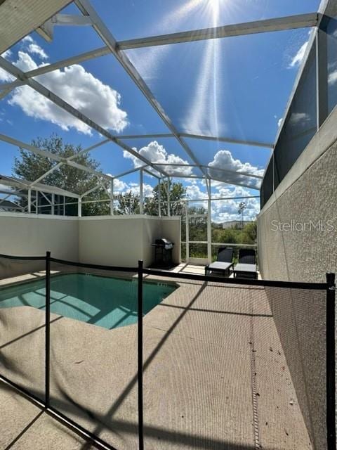 view of swimming pool featuring a lanai and a patio area