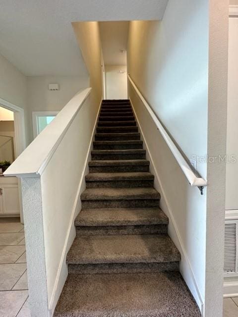 staircase featuring light tile patterned floors