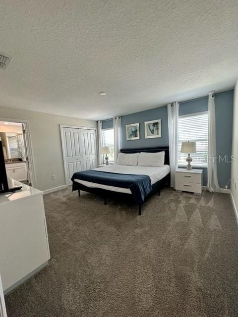 carpeted bedroom featuring a closet and a textured ceiling