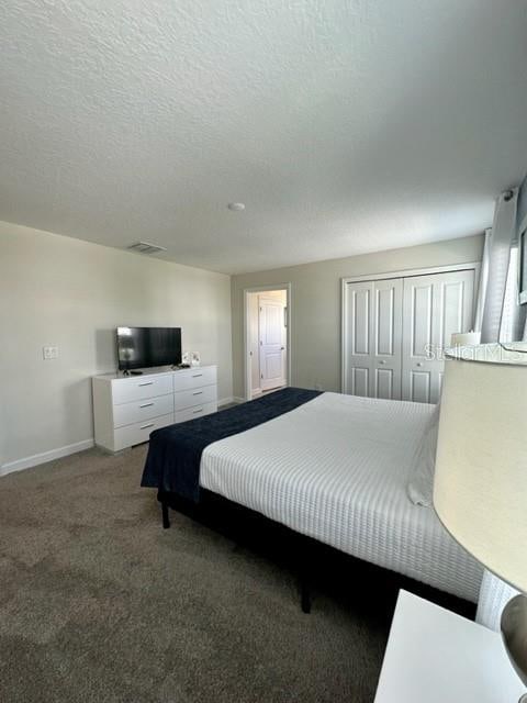 bedroom with a closet, carpet floors, and a textured ceiling