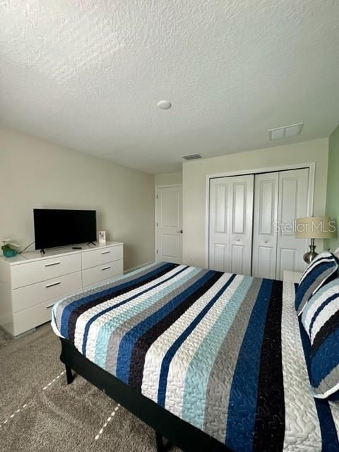 bedroom with a textured ceiling, a closet, and carpet flooring