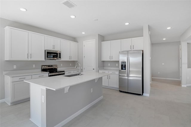 kitchen with white cabinetry, stainless steel appliances, a center island with sink, and sink