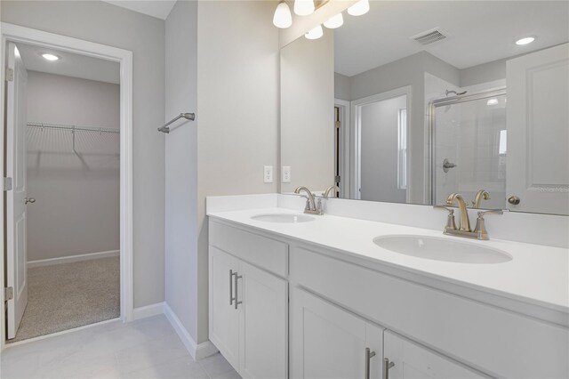 bathroom featuring a shower with door and vanity