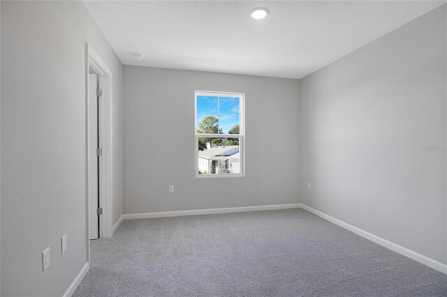 carpeted empty room with a textured ceiling