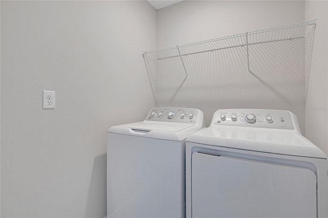 clothes washing area featuring separate washer and dryer