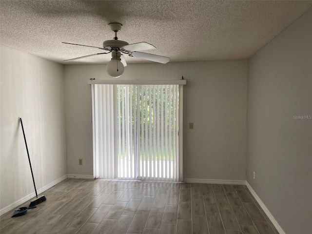 spare room featuring a textured ceiling, ceiling fan, hardwood / wood-style flooring, and a wealth of natural light