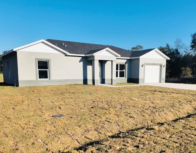 single story home featuring a front lawn, an attached garage, and stucco siding