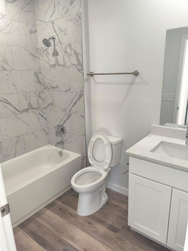 full bathroom featuring shower / bath combination, baseboards, toilet, wood finished floors, and vanity