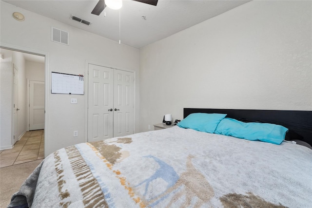 bedroom featuring tile patterned floors, a closet, and ceiling fan