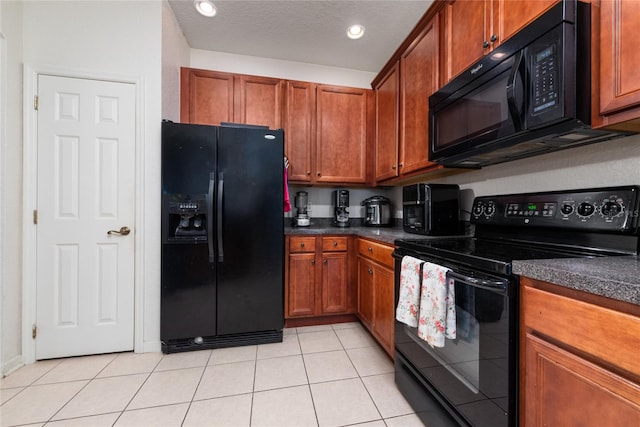 kitchen with light tile patterned flooring and black appliances