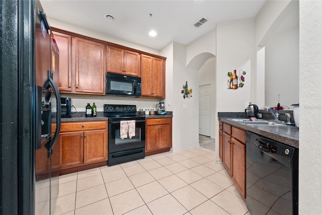 kitchen with light tile patterned floors, black appliances, and sink