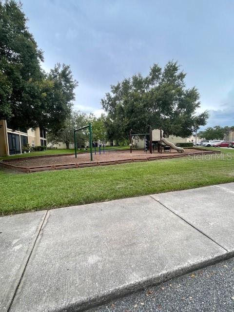 surrounding community featuring a playground and a lawn