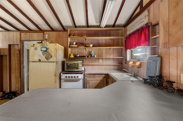 kitchen with lofted ceiling with beams, white appliances, sink, and wood walls