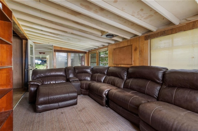 living room featuring lofted ceiling with beams and wood walls