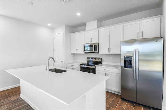 kitchen featuring appliances with stainless steel finishes, a kitchen island with sink, white cabinets, and sink