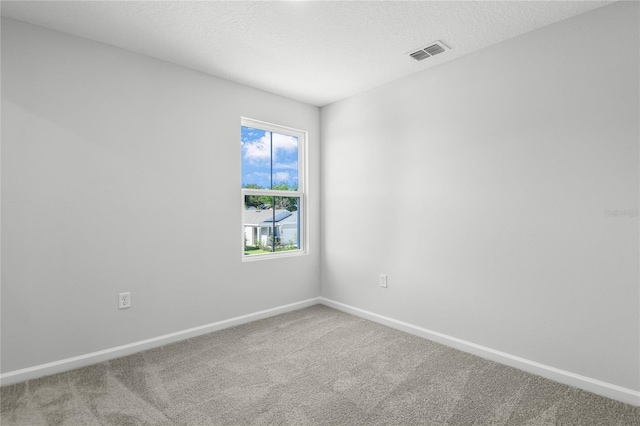 carpeted spare room with a textured ceiling