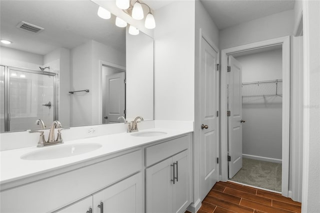 bathroom with vanity and a shower with door