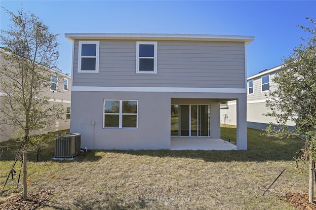 rear view of property with central AC unit and a lawn