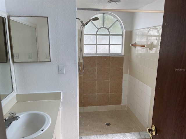 bathroom featuring vanity and tiled shower