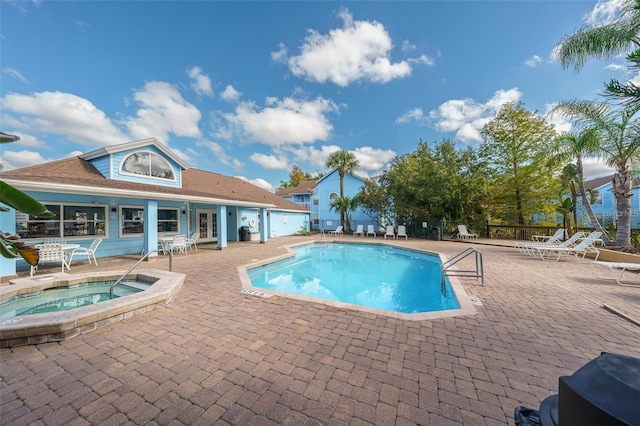 view of pool featuring a patio and a hot tub