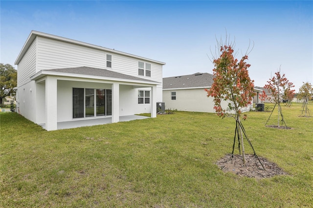 back of property with cooling unit, a lawn, and a patio