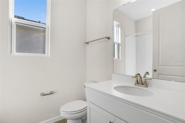 bathroom with toilet, walk in shower, plenty of natural light, and vanity