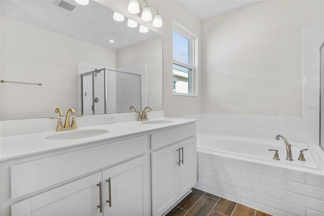 bathroom featuring vanity and independent shower and bath