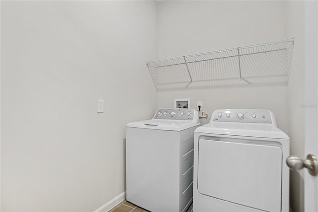 laundry room with light tile patterned floors and washing machine and clothes dryer