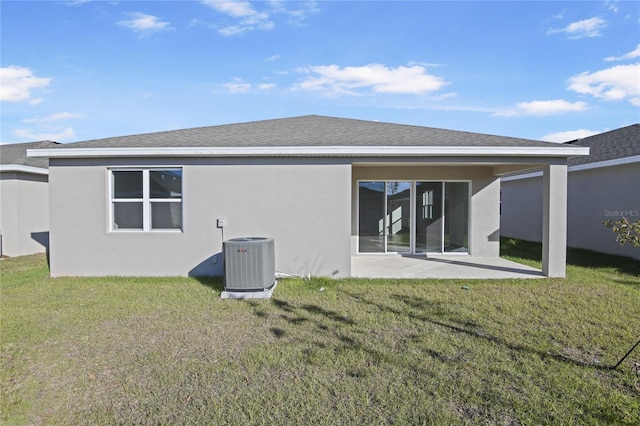 back of property with a patio area, central AC unit, and a yard