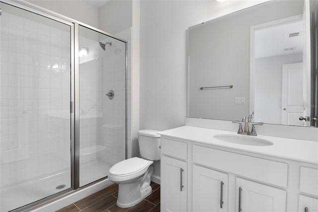 bathroom featuring an enclosed shower, vanity, and toilet