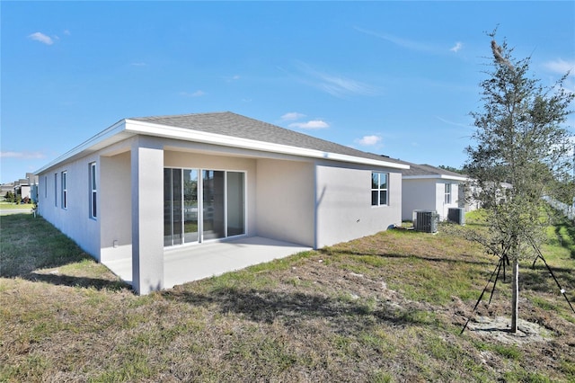 back of property with a patio area, cooling unit, and a lawn