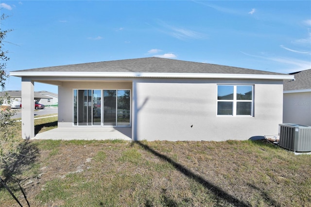 rear view of house with a patio area, central AC, and a lawn