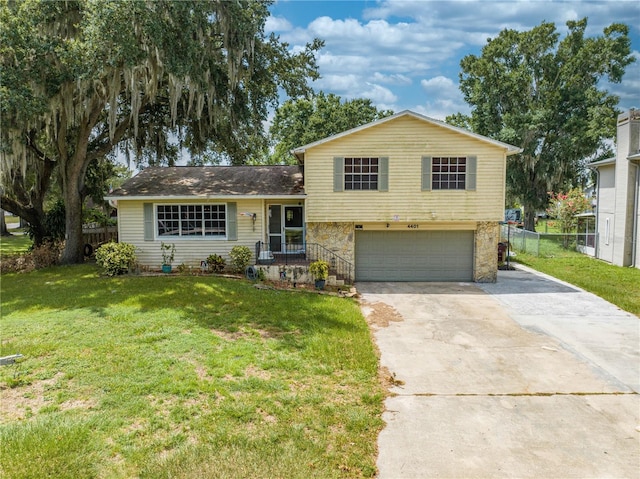 split level home with a garage and a front lawn