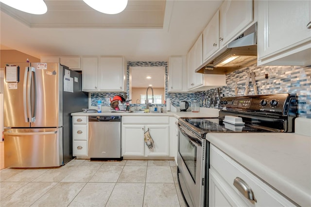 kitchen featuring a tray ceiling, appliances with stainless steel finishes, tasteful backsplash, and white cabinets