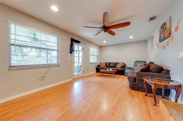 living room featuring light hardwood / wood-style flooring and ceiling fan