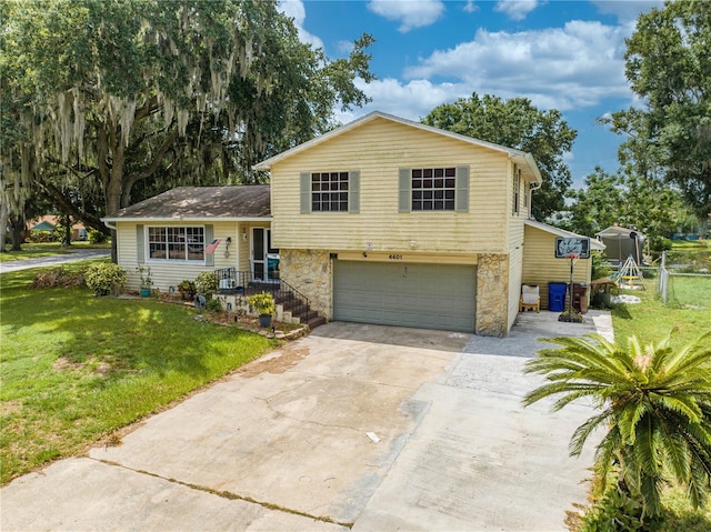 tri-level home featuring a garage and a front lawn