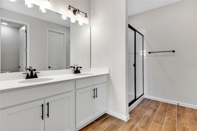 bathroom featuring a shower with shower door and vanity