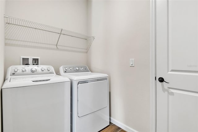 clothes washing area with hardwood / wood-style floors and washing machine and clothes dryer