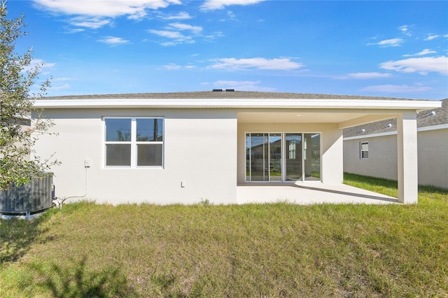 back of house featuring a patio area, a lawn, and central AC