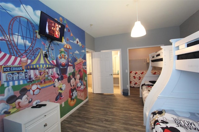 bedroom with a walk in closet and dark hardwood / wood-style flooring