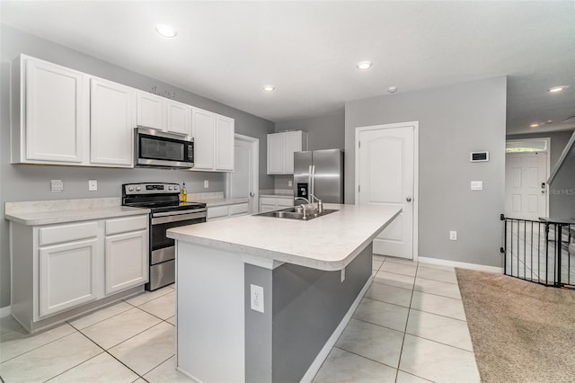 kitchen with white cabinetry, light tile patterned floors, a center island with sink, appliances with stainless steel finishes, and sink