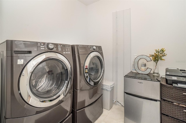 laundry area with light tile patterned flooring and washing machine and dryer