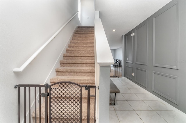 staircase featuring light tile patterned flooring