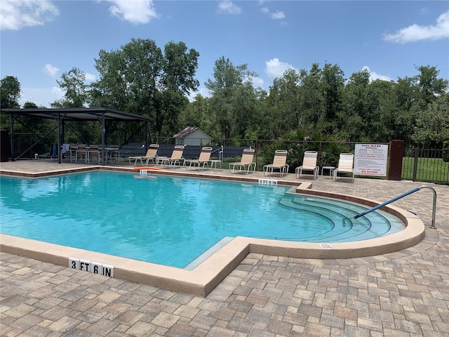 pool featuring a gazebo, a patio area, and fence