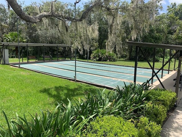 view of community featuring shuffleboard and a yard