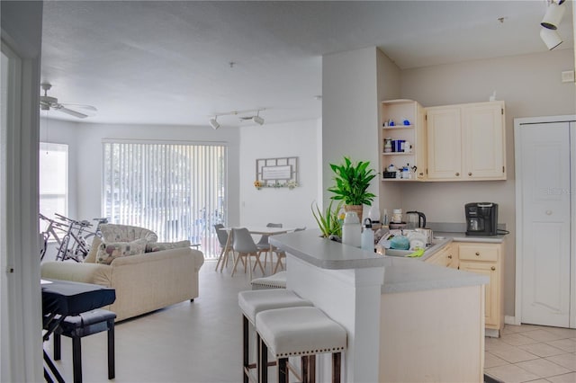 kitchen featuring a kitchen breakfast bar, light tile patterned floors, and ceiling fan