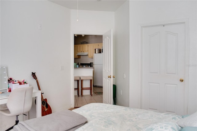 tiled bedroom with white fridge