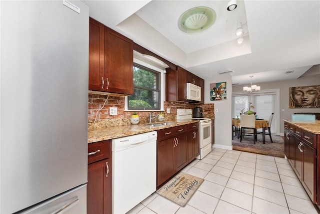 kitchen featuring light tile patterned flooring, pendant lighting, sink, decorative backsplash, and white appliances