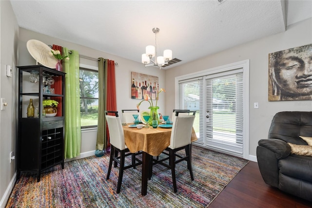 dining area featuring dark hardwood / wood-style flooring and a chandelier