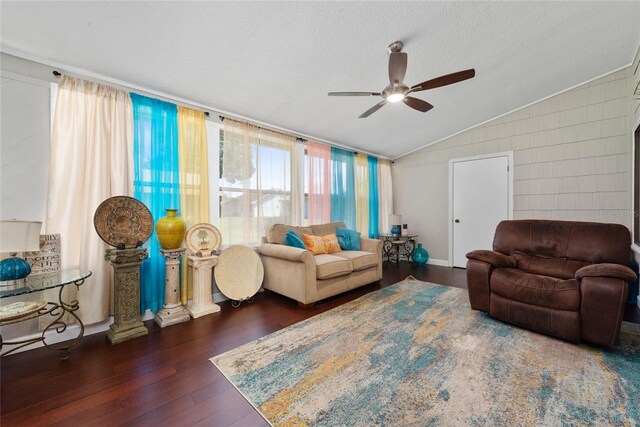 living room featuring a textured ceiling, hardwood / wood-style flooring, vaulted ceiling, and ceiling fan